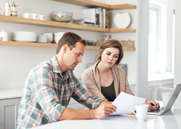 couple working on computer together in the kitchen